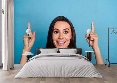 Photo portrait of lovely young lady point up excited empty space dressed stylish colorful print garment isolated on blue color background Wall mural