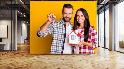 Photo portrait of man holding keys woman with home model isolated on vivid yellow colored background Wall mural