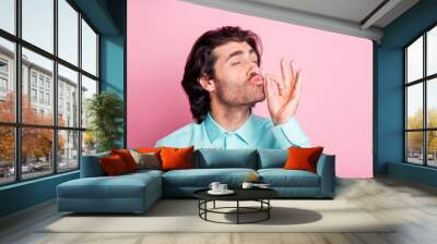 Photo portrait of man showing chef's kiss isolated on pastel pink colored background Wall mural