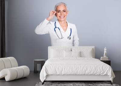 Photo portrait of pretty retired female clinic professional doctor cheersul smile wear white robe uniform isolated on gray color background Wall mural