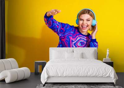 Photo portrait of pretty young girl dance headphones listen music wear trendy colorful blue outfit isolated on yellow color background Wall mural