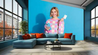 Photo portrait of pretty young girl hold gadget credit card paying wear trendy pink outfit isolated on blue color background Wall mural