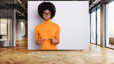 Photo portrait of shy afro american girl touching pointing fingers together looking at blank space isolated on clear grey colored background Wall mural