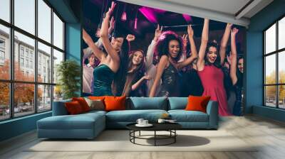 Photo portrait of wild crowd dancing together with hands in air at nightclub wearing beautiful formal dresses Wall mural