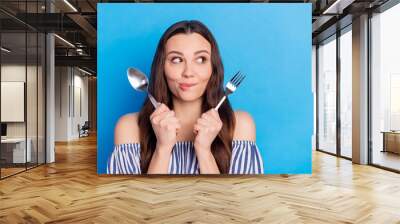 Photo portrait woman hungry wait for dinner with fork knife biting lip looking copyspace isolated bright blue color background Wall mural