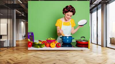 Photo vintage stylish girl cook delicious dinner pasta boil sauce pan enjoy cook table cucumber tomato leisure wear trendy yellow dotted dress hair rollers isolated green color background Wall mural