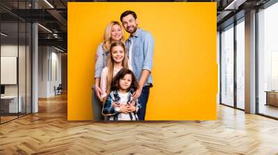 Photo wife mother lady handsome husband dad couple hug adopted little school girl daughter small son boy happy together wear casual shirts clothes isolated yellow color background Wall mural