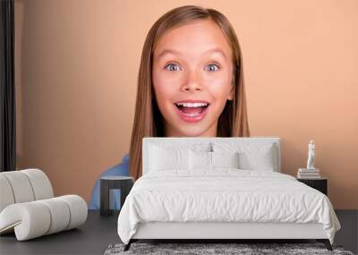 Portrait of astonished positive girl open mouth toothy smile unbelievable isolated on beige color background Wall mural