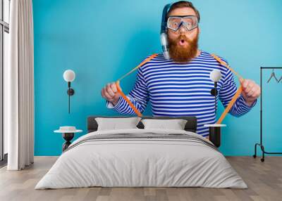 Portrait of astonished redhair man train watersport swim coral reef pull his modern suspenders wear protective mask tube white shorts nautical vest isolated over blue color background Wall mural