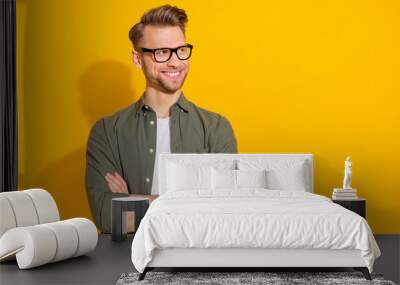 Portrait of attractive cheerful content guy folded arms thinking copy empty space isolated over bright yellow color background Wall mural