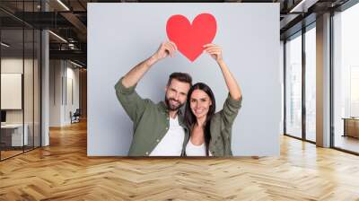 Portrait of attractive cheerful couple hugging holding heart card shape form cupid isolated over grey pastel color background Wall mural