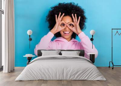 Portrait of attractive cheerful trendy bushy haired funky girl showing ok-sign like glasses isolated over bright blue color background Wall mural