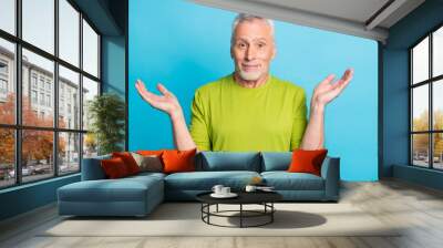 Portrait of attractive clueless grey-haired man shrugging shoulders isolated over vibrant blue color background Wall mural