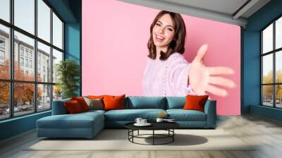 Portrait of attractive glad cheerful wavy-haired girl giving you hand come with me isolated over pink pastel color background Wall mural