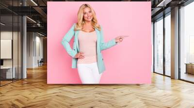 Portrait of attractive trendy cheerful wavy-haired woman demonstrating copy empty blank space ad isolated over pink pastel color background Wall mural