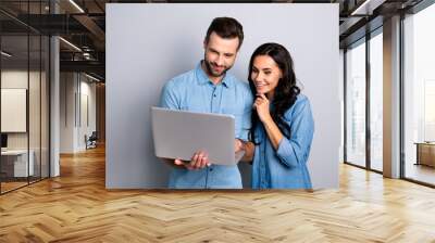 Portrait of charming inspired students using electronic devices watching videos browsing sites social networks isolated dressed in blue denim clothing on gray background Wall mural