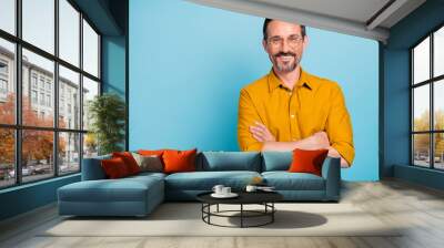 Portrait of charming mature man true boss feel content emotions wear yellow shirt isolated over blue color background Wall mural