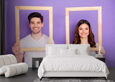 Portrait of cheerful man woman hold wooden picture frame wear white t-shirt casual style isolated over violet color background Wall mural