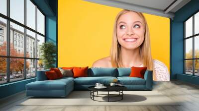 Portrait of cheerful toothy girl with naked shoulder looking with eyes at copyspace empty place having white straight healthy teeth isolated on yellow background Wall mural