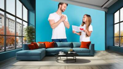 Portrait of cute girl giving paper card satisfied dad look each other have good mood isolated on blue color background Wall mural