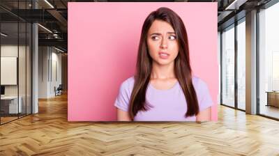 Portrait of emotional young woman girl feel disgust look empty space dressed violet t-shirt isolated on pink color background Wall mural