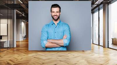 portrait of happy fashionable handsome man in jeans shirt crossing hands and look at camera Wall mural