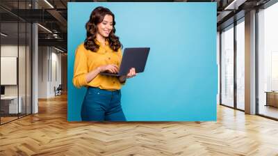 Portrait of her she nice attractive lovely cheerful cheery wavy-haired girl holding in hands laptop creating presentation isolated over bright vivid shine vibrant green blue turquoise color background Wall mural