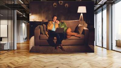 Portrait of his he her she nice attractive cheerful cheery spouses sitting on divan enjoying watching video at night dark home house living-room apartment hotel Wall mural