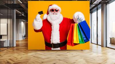 Portrait of his he nice attractive cheerful fat Santa holding in hands buyings plastic card shop retail store visit pay-pass isolated bright vivid shine vibrant yellow color background Wall mural