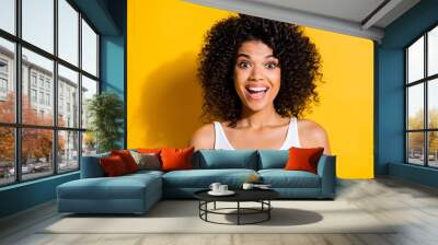 Portrait of impressed cheerful dark skin lady open mouth smile look camera isolated on yellow color background Wall mural