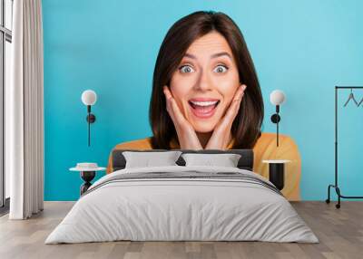 Portrait of impressed cheerful lady hands touch cheeks open mouth isolated on blue color background Wall mural