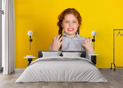 Portrait of little schoolchild girl grinning wear uniform isolated on yellow color background Wall mural