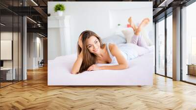 Portrait of lovely sensual girl lying on stomach in bed looking away dreaming having good memories enjoying free time in modern apartments Wall mural