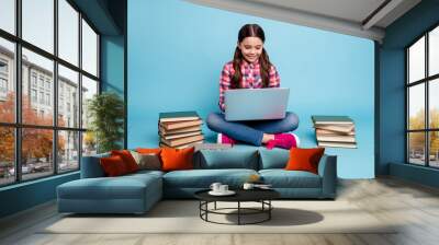 Portrait of nice attractive cheerful smart clever girl nerd wearing checked shirt sitting in lotus pose research search digital web library academic isolated over bright vivid shine blue background Wall mural