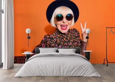 Portrait of old smiling funky crazy positive good mood lady take selfie showing v-sign isolated on orange color background Wall mural