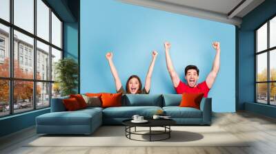 Portrait of positive crazy two people woman man have luck win lottery raise fists scream yeah wear casual style clothing isolated over blue color background Wall mural