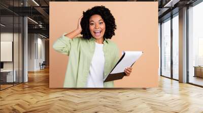 Portrait of pretty young woman clipboard empty space wear green shirt isolated on beige color background Wall mural