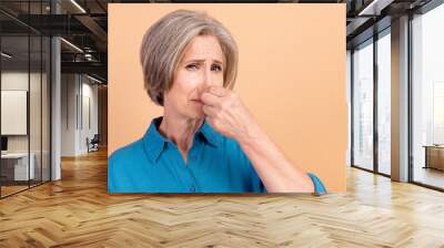 Portrait of retired person with white gray hairdo wear blue shirt fingers close nose from stinky smell isolated on pastel color background Wall mural