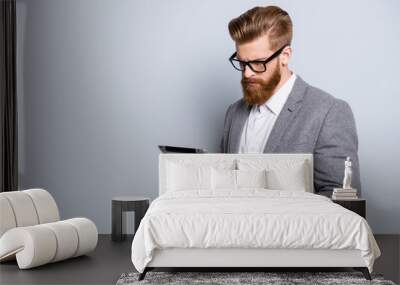 Portrait of serious confident  bearded man in formalwear holding digital tablet and work Wall mural