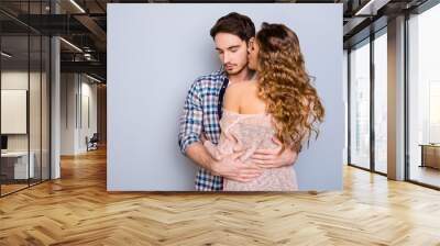 Portrait of sexy provocative woman with curly hair kissing dreamy lover enjoying smell isolated on grey background. Passion concept Wall mural