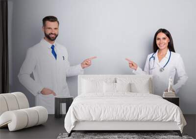 Portrait of two attractive cheerful medics showing copy space insurance vaccine solution isolated on grey color pastel background Wall mural