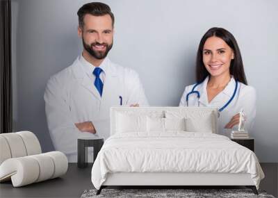 Portrait of two cheerful intelligent surgeon doctors crossed hands isolated on grey color background Wall mural