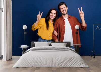 Portrait of two cheerful nice people hold arm fingers demonstrate hello greetings v-sign isolated on blue color background Wall mural