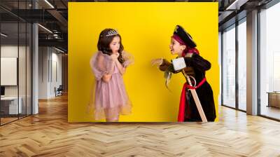 Portrait of two little kids halloween princess pirate costume dead scary arm isolated on yellow color background Wall mural