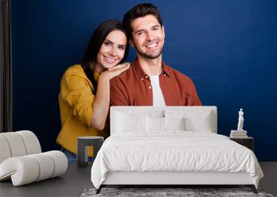 Portrait of two peaceful cheerful partners toothy smile embrace crossed arms empty space isolated on blue color background Wall mural