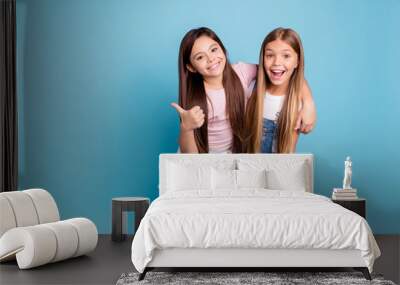 Portrait of two people nice cute lovely charming dreamy attractive cheerful straight-haired pre-teen girls siblings showing aside ad promotion copy space isolated on blue turquoise background Wall mural