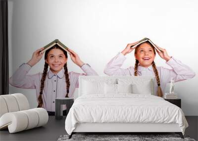 Portrait of two person nice attractive lovely charming cute cheerful cheery playful foolish pre-teen girls holding book like roof on head isolated over bright vivid shine orange background Wall mural