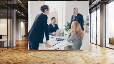 Portrait of two stylish business persons in suits having disagreement, war, conflict, standing near desktop in front of each other, face to face with disrespect expression in work place, station Wall mural