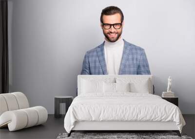 Portrait of  virile, attractive, stunning man in glasses using, having tablet in hands, looking at camera, standing over gray background Wall mural