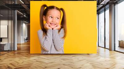 Portrait of young cute adorable smiling girl child kid hold hands under chin isolated on yellow color background Wall mural